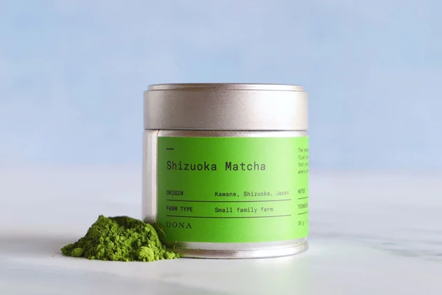 Matcha green tea powder on a wooden spoon showing vibrant green color and fine particle texture, key indicators of quality and EGCG content