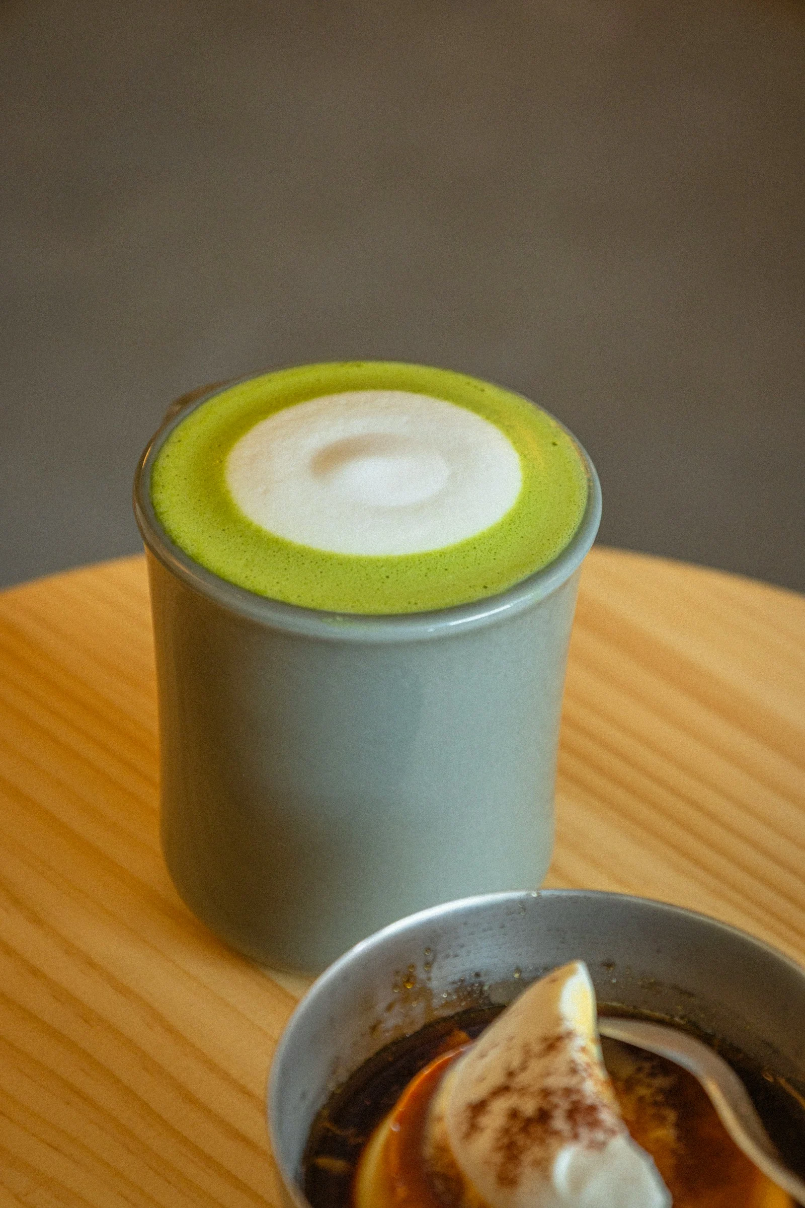 Barista preparing matcha latte at café counter with creamy foam art - latte grade matcha powder delivers best cost per cup margin for food service operations in 2026